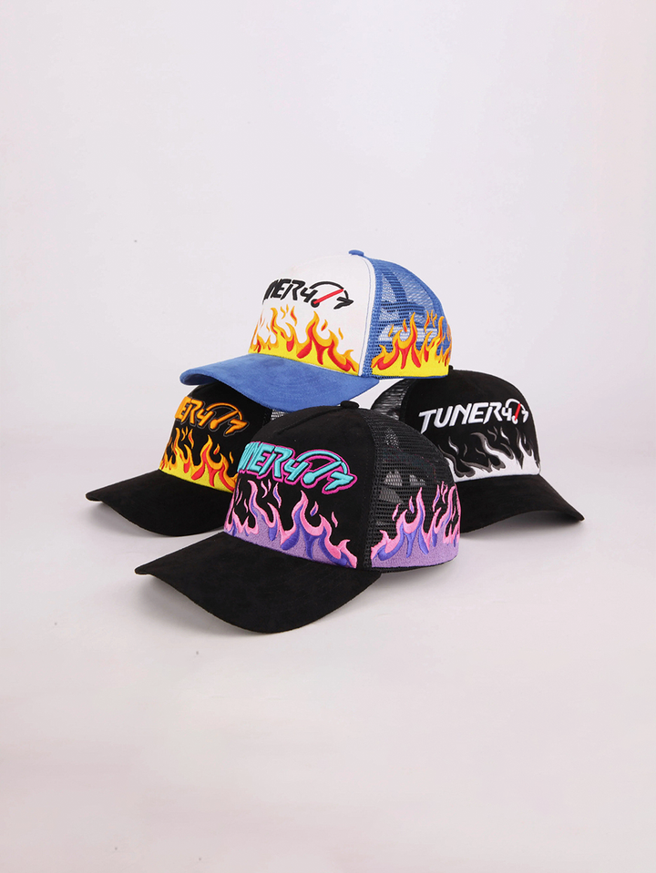 Four TUNER4/7 trucker hats with embroidered flame designs in blue and white, black and orange, black and purple, and black and white.